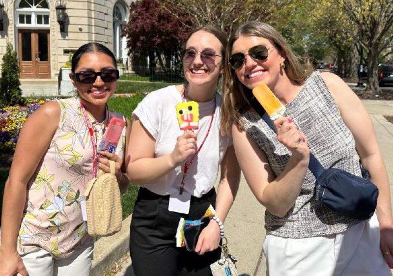 Three female Hope College students eating ice cream and smiling