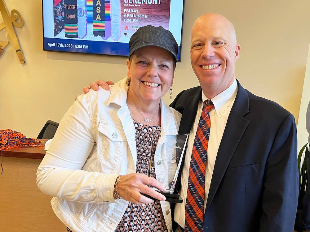 Michele Sterk '91 Schoon receives the Hope for Humanity Award from Brian Morehouse