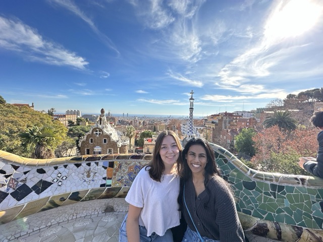Two students sitting in front of a mosaic wall overlooking Barcelona, Spain